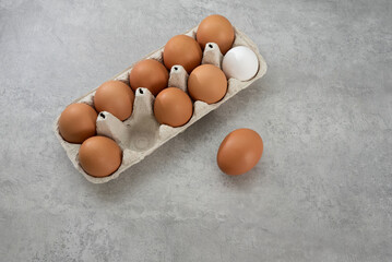 Chicken eggs lie in a tray on a light background. Fresh egg on morning breakfast. Concept farm products and natural nutrition