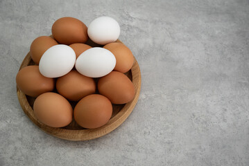 Chicken eggs lie on a wooden plate. Fresh egg for morning breakfast. Concept of agricultural products and natural food