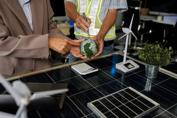 Two colleagues discussing data working and tablet, laptop with on Construction Site project, green energy and solar panel concept.