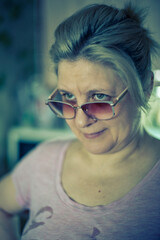 A woman wearing sunglasses and a pink shirt