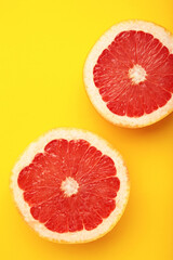 Fresh raw grapefruit on yellow background. Vertical photo