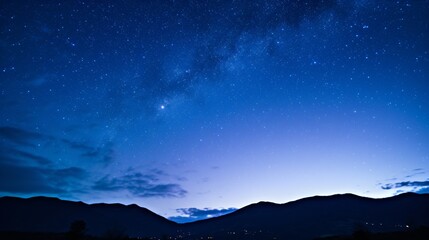 Fototapeta premium Stunning night sky filled with bright stars over a silhouette of mountain peaks. 