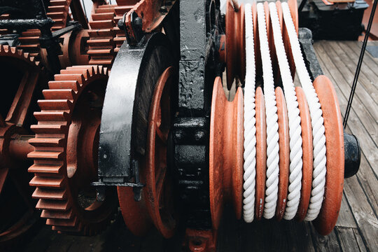 A series of white ropes wound around a large, red wheel or pulley at Old Whaling Station