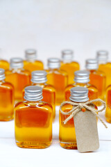 Honey in the glass bottles for wedding gift with brown tag. Wedding gift for the guest. Wedding favors concepts.