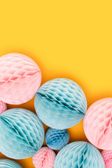 Pink and blue tissue paper balls different sizes on a yellow background. Creative composition.