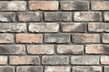 Obraz premium Rustic brick wall with varied textures and hues creates a vintage aesthetic in an urban setting