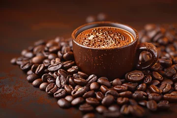  A ceramic coffee cup sits on a bed of roasted coffee beans © NikahGeh