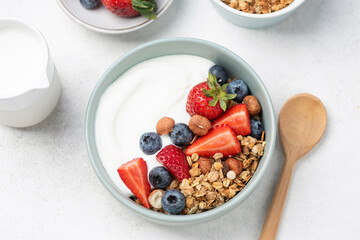 Greek yogurt with crunchy oat honey granola and fresh berries in a bowl. Healthy breakfast or fitness snack meal