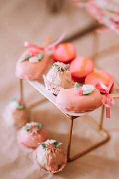 strawberry themed cake pops arranged on party table