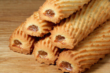 Crunchy treats with sweet filling stacked elegantly on wooden board