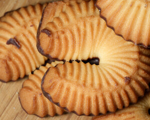 Delicious cookies with rich chocolate coating on wooden surface