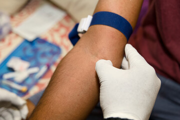 Med professional drawing blood from arm with tourniquet