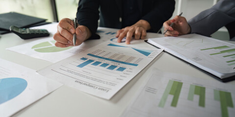 Analysis and Data Review. Close-up of colleagues reviewing financial reports and graphs together.