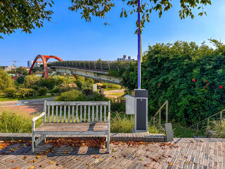 Scenic Park with Wooden Bench and Red Bridge