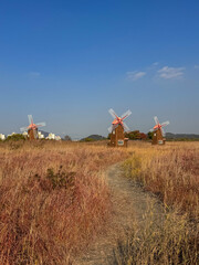 Three Windmills in an Autumn Field