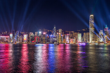 The night view Hong Kong skyline at night with lights and skyscrapers over sea with laser beams, lights show.
