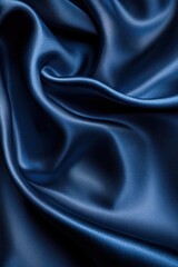 Fototapeta premium Smooth, deep blue satin fabric draped elegantly, creating folds