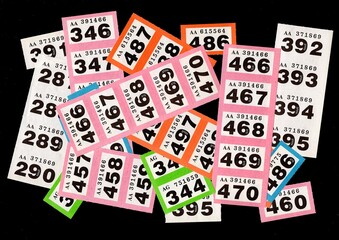 Fototapeta na wymiar A montage of vintage raffle tickets on a black background.