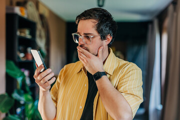 man looking at his mobile phone screen with a shocked