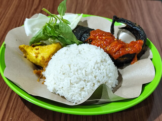 Lalapan lele, traditional Indonesian food with fresh vegetables and mashed chili sauce.