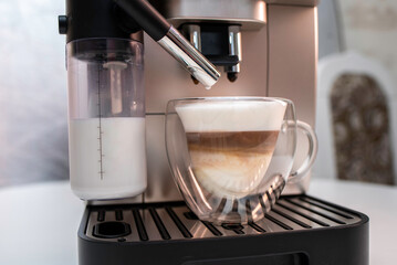 Modern coffee machine with glass bowl, makes coffee, cappuccino, espresso and latte