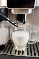 Modern coffee machine with glass bowl, makes coffee, cappuccino, espresso and latte