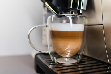 Modern coffee machine with glass bowl, makes coffee, cappuccino, espresso and latte