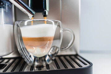 Modern coffee machine with glass bowl, makes coffee, cappuccino, espresso and latte