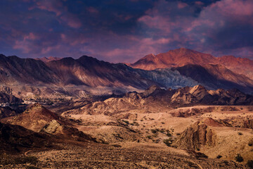 Copper Hike trail, winding gravel dirt road through Wadi Ghargur riverbed and rocky limestone Hajar Mountains in Hatta, United Arab Emirates
