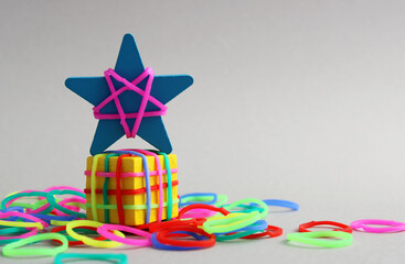 Colorful rubber bands tied to a cube and a wooden star