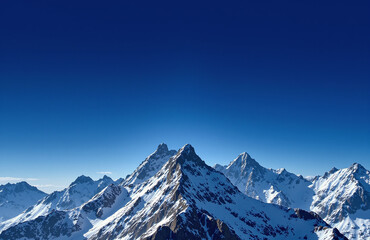 Rugged snow-capped mountain range under a deep blue sky with contrail