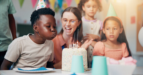 Child, birthday cake and blow candles in classroom for party celebration, school event or growth development. Friends, teacher or happy people at learning academy with care or support on special day