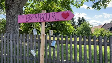 Regensburg, Germany - August 28, 2023: A traditional pink Bavarian sign reading "BIXNMACHEREI" hangs on a wooden post, symbolizing that only girls have been born in this house.