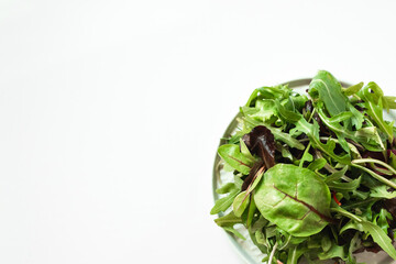 Mix of fresh green salad with arugula, beetroot leaves, basil on a white background. Detox, vegetarian, diet and healthy eating.  Copy space