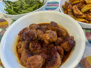 Dinner Of Meatballs With Gravy, Green Beans, And Home Cut French Fries