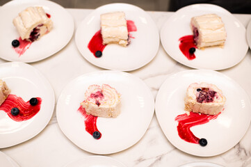Pieces of tasty meringue roll with jam, cream, strawberry, blueberry
