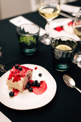 Piece of tasty meringue roll with jam, cream, strawberry, blueberry
