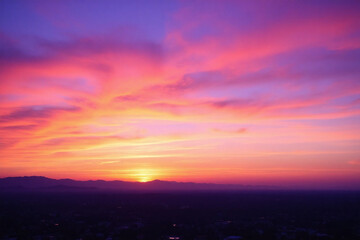 colorful sunset over a city with mountains in the background