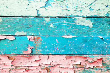 Blue peeling paint on the wooden surface, texture background with peeling paint of light blue color