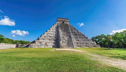 Ancient Mayan pyramid in Chichen Itza, Mexico, surrounded by lush greenery and clear skies