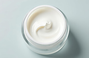 White cosmetic cream swirling in a jar on transparent background, top view