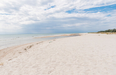 picturesque summer beach with white sand, blue sea and rich sky. A sandy beach