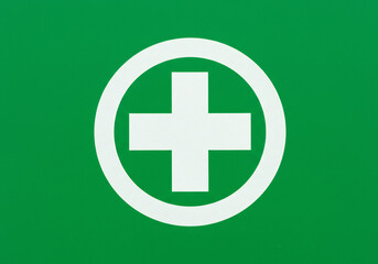 Fototapeta premium White Medical Cross in a Circle on Green Background