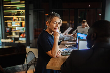 Confident mature businesswoman in meeting at modern office