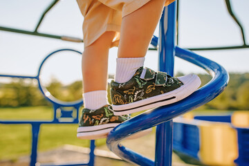 Kids playing at a playground in the summer with a focus on footwear,