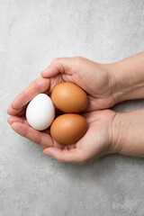 Raw chicken eggs in woman's hands