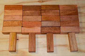 Wooden blocks arranged to show the concept of people working as a team cooperating to lift a heavy load