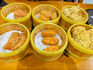 Various type of Fried Dumplings in a bamboo steamer bowl. Chinese food menu.