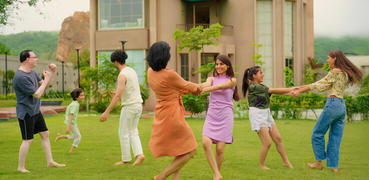 Indian happy family group play game running with cute son kid boy enjoy day outdoor home park Adult mom dad man woman young male female teen girl child have fun joy spend time at outside garden house - Powered by Adobe