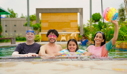 Indian happy family group with teen child dancing look cam enjoy outdoor resort pool edge trip mom dad young adult girl boy make female do pose have fun joy spend day time at outside water park